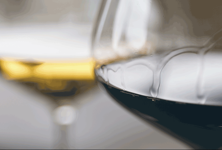 Gros plan sur un verre de vin rouge avec des larmes de vin